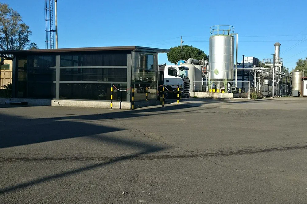 L'ingresso dell'impianto di Catania: la palazzina uffici a vetri e i serbatoi alle spalle.